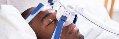 Man Wearing CPAP Mask Sleeping On Bed